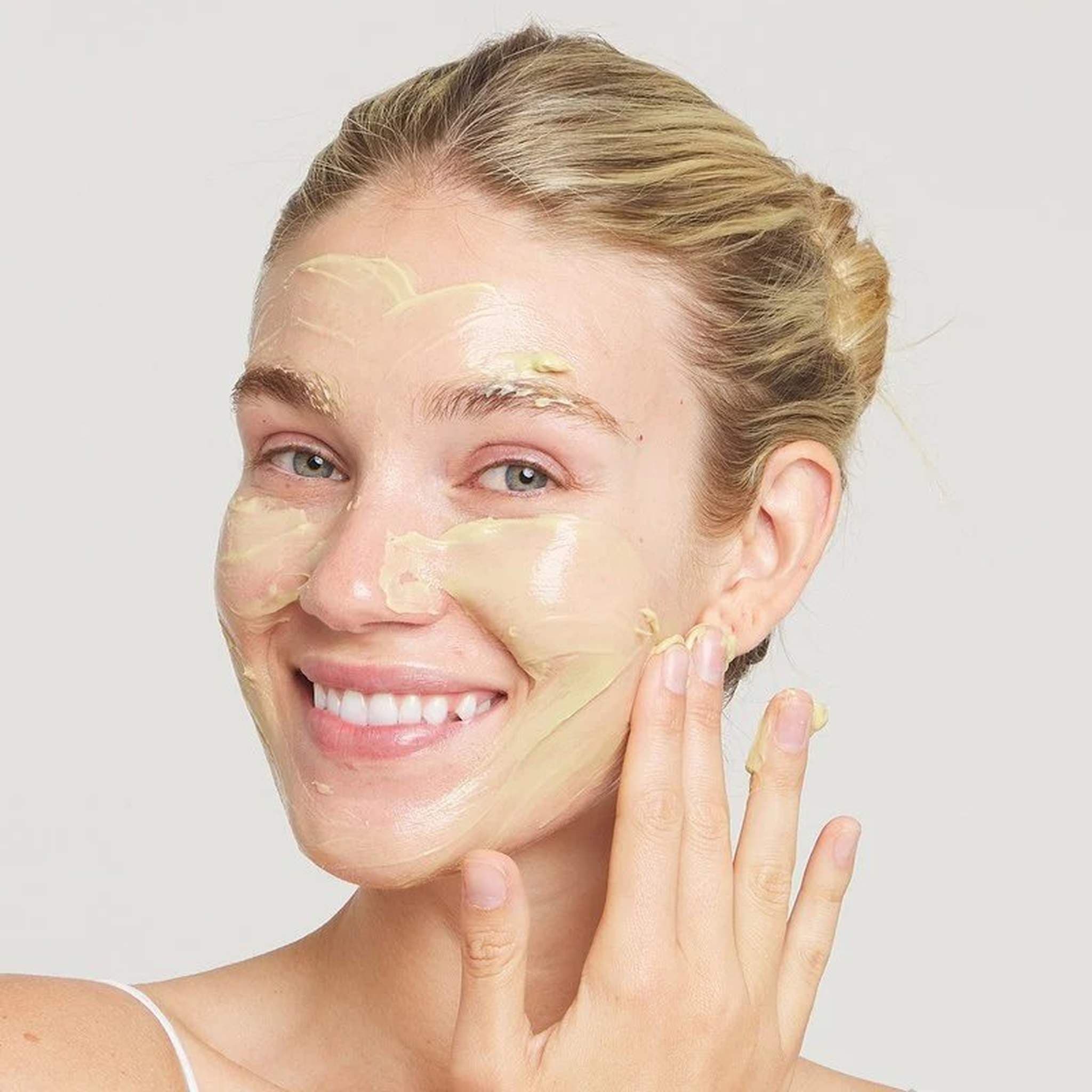 Woman applying Marini Skinsolutions Skin Zyme enzyme face mask to her skin
