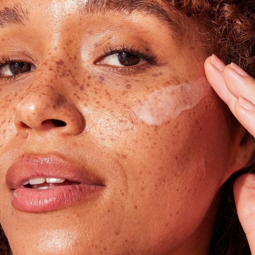 Close-up of a freckled cheek with Naked Sundays CabanaClear illuminating water gel serum SPF50 swiped on