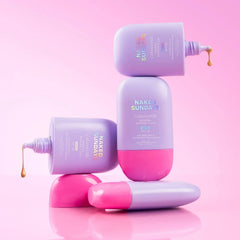 Naked Sundays CabanaMilk SPF50 barrier fluid bottles stacked with formula dripping on pink