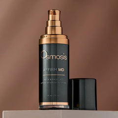 Osmosis Affirm MD Neck and Face Lift bronze pump bottle against a warm brown backdrop