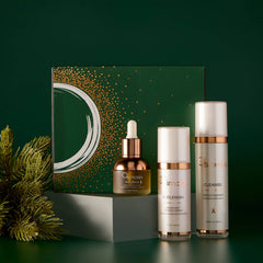 Osmosis Let It Glow Kit gift box with Nourish Replenish and Cleanse displayed on pedestals with pine branches