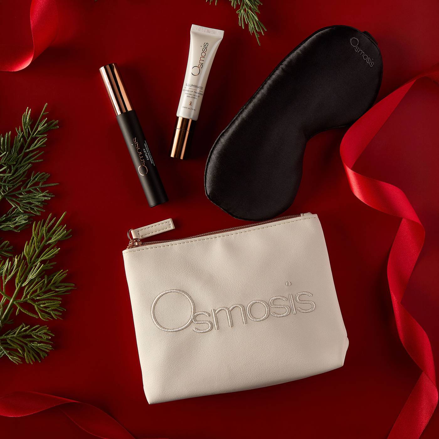 Osmosis Merry and Bright Eye Kit styled on a red background with pine branches and ribbon