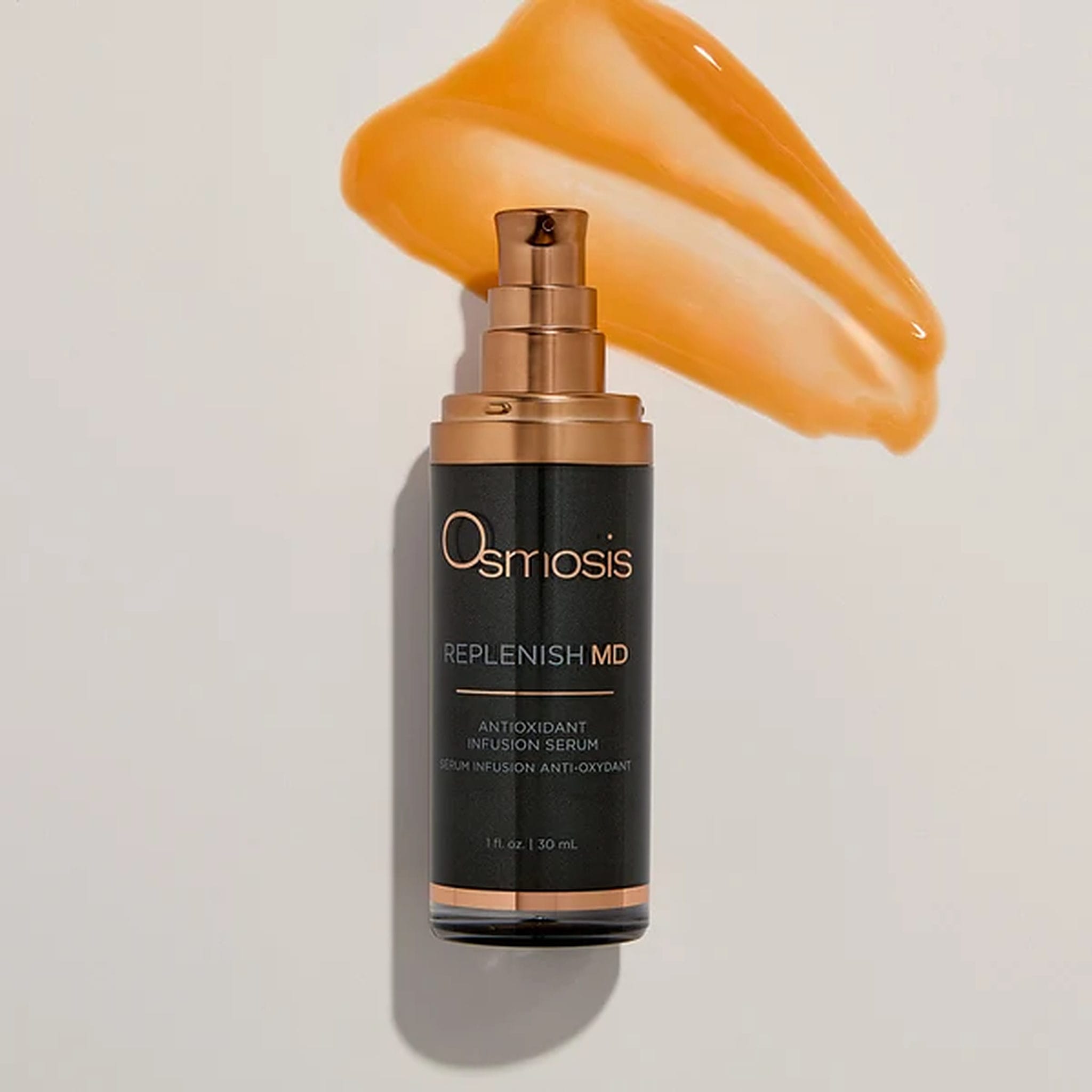 Osmosis Replenish MD serum bottle beside golden orange antioxidant serum texture swatch