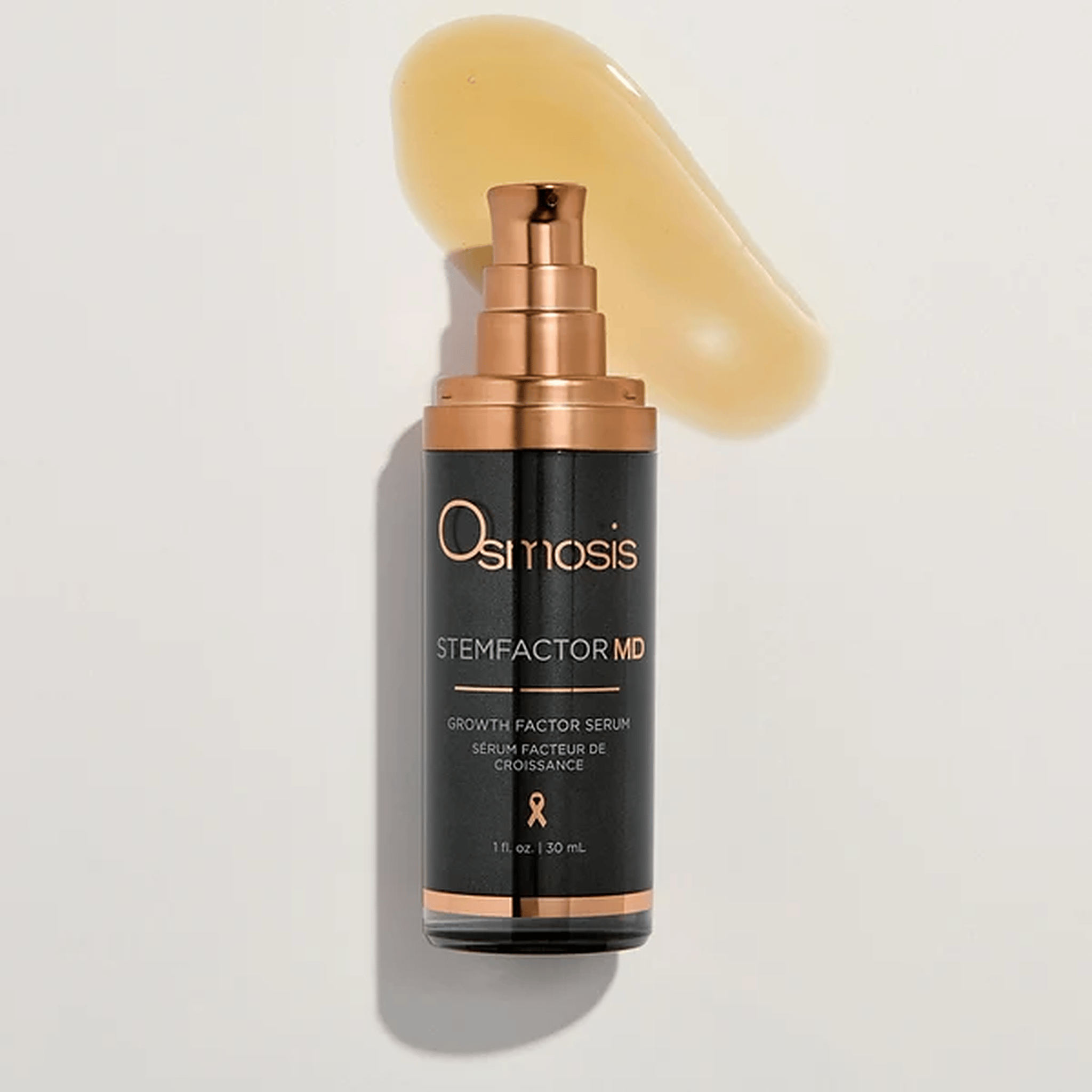 Osmosis StemFactor MD growth factor serum bottle beside a smear of golden serum texture