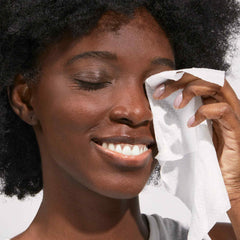 Woman wiping her face with a pure goat milk facial cleansing wipe