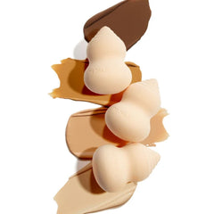 Three blending sponges stacked beside swiped foundation shades