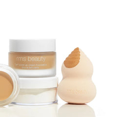 Blending sponge next to RMS Beauty Un Cover-Up cream foundation jars