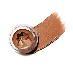 Buriti Bronzer compact and swatch styled in a lifestyle flat lay