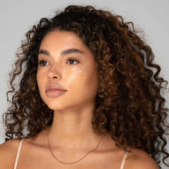 Model with medium skin tone showing sunkissed bronzer finish