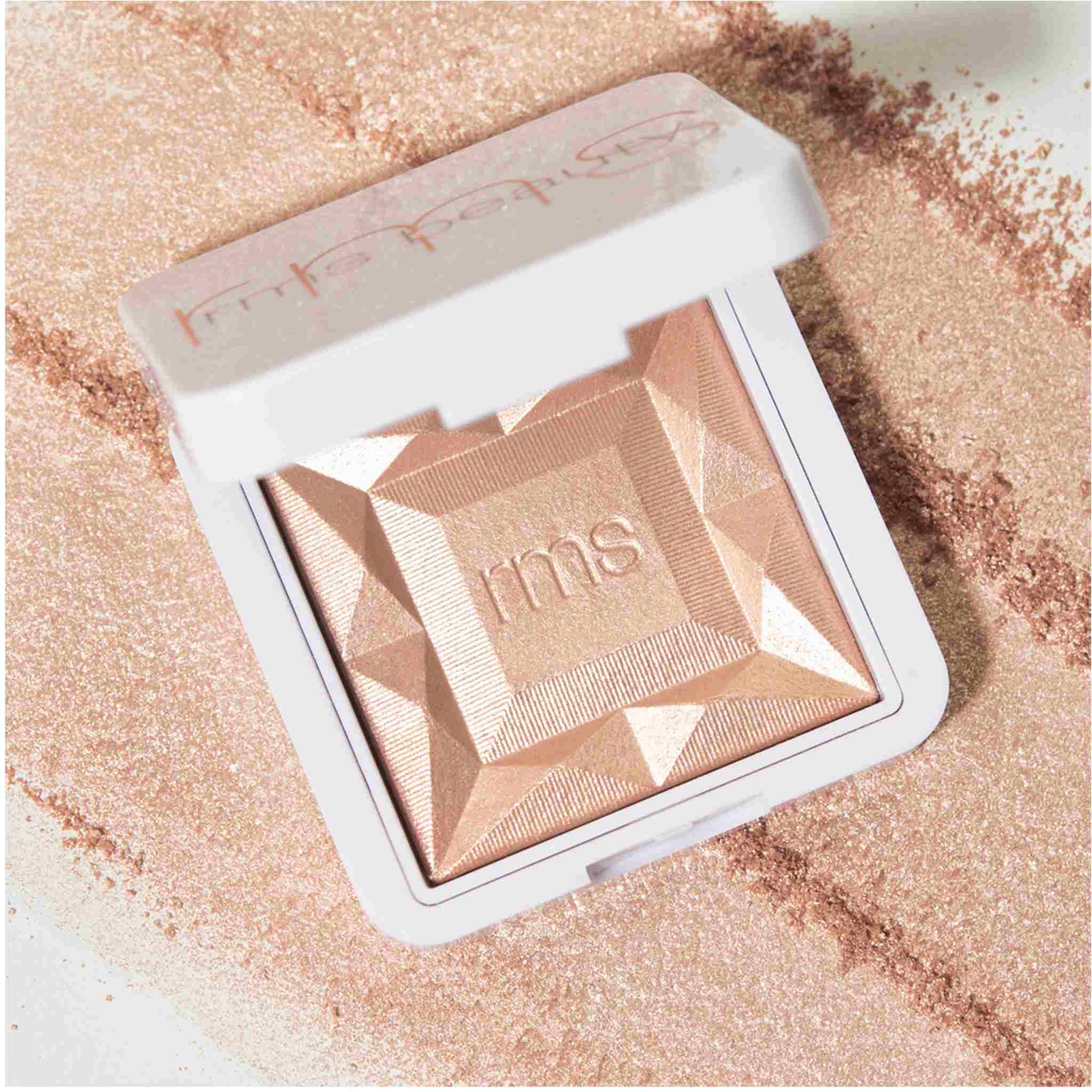 RMS Beauty ReDimension Hydra Dew compact with loose shimmer powder scattered around 3