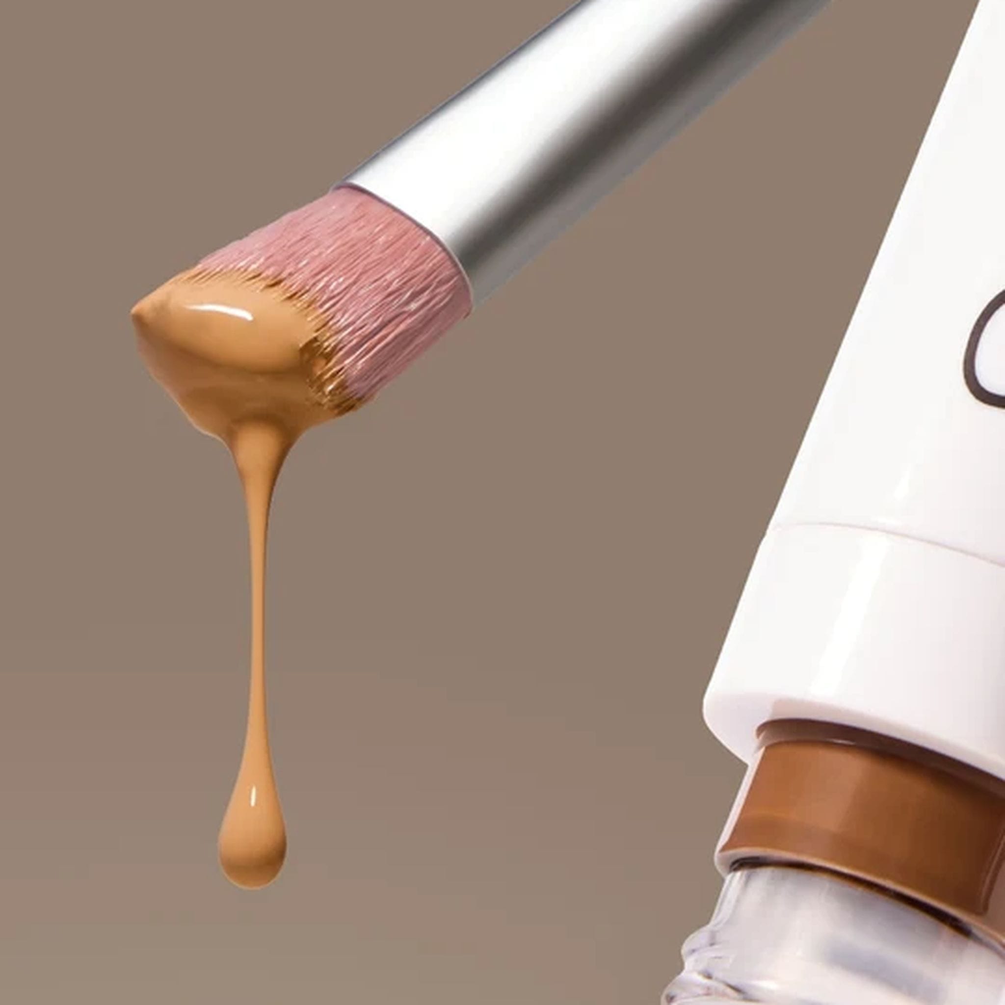 Skin2Skin Concealer Brush dipped in cream foundation beside product tube