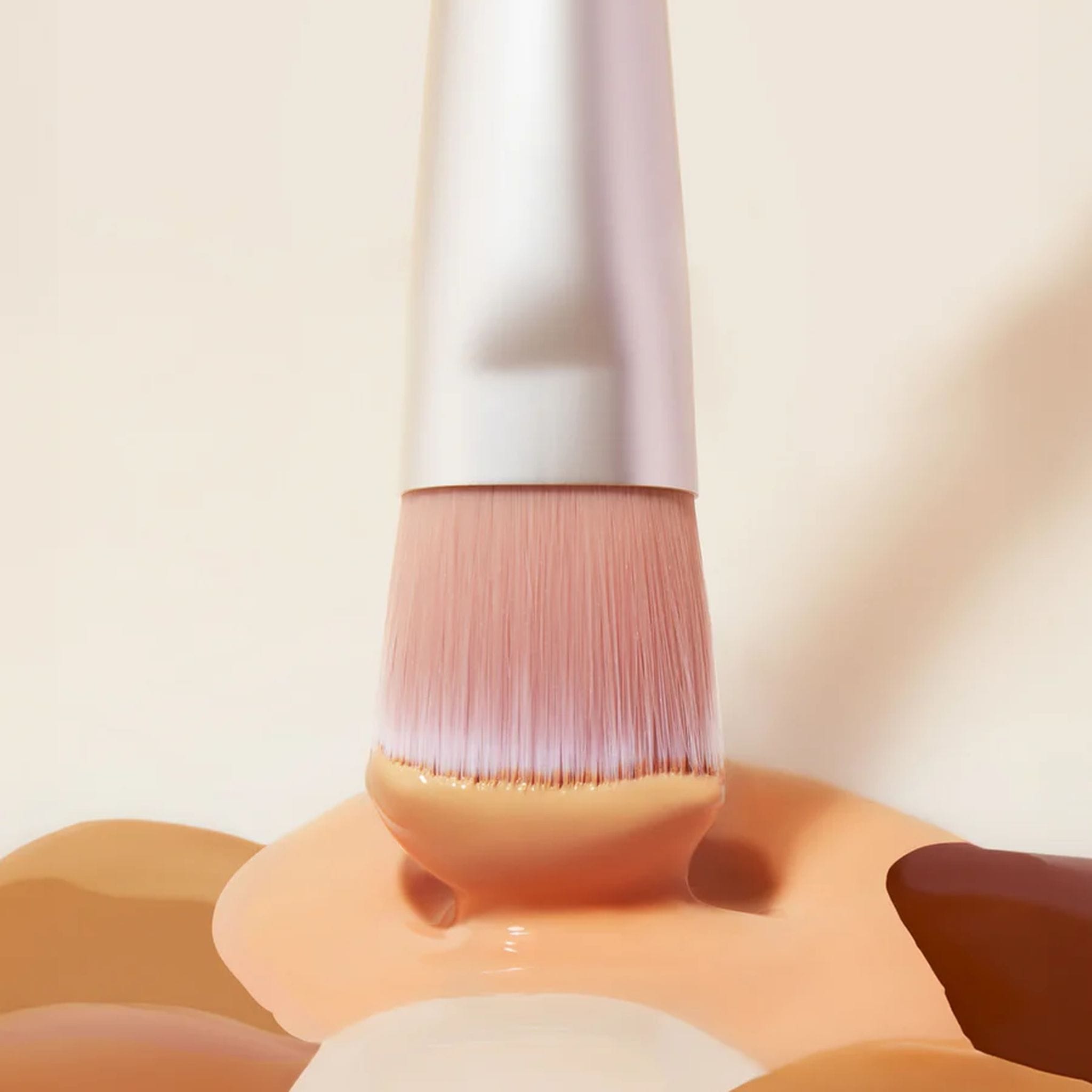 Close up of Skin2Skin Everything Brush bristles dipped in liquid foundation swatches