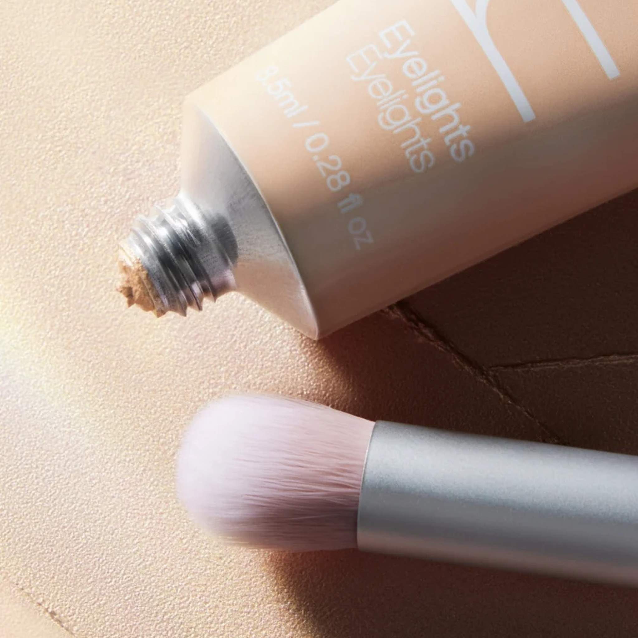 Skin2Skin Everything Eye Polish Brush next to RMS Beauty Eyelights cream shadow tube