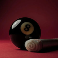 Skin2Skin foundation brush resting against an eight ball on red background