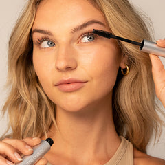 Model applying Straight Up mascara to upper lashes with wand