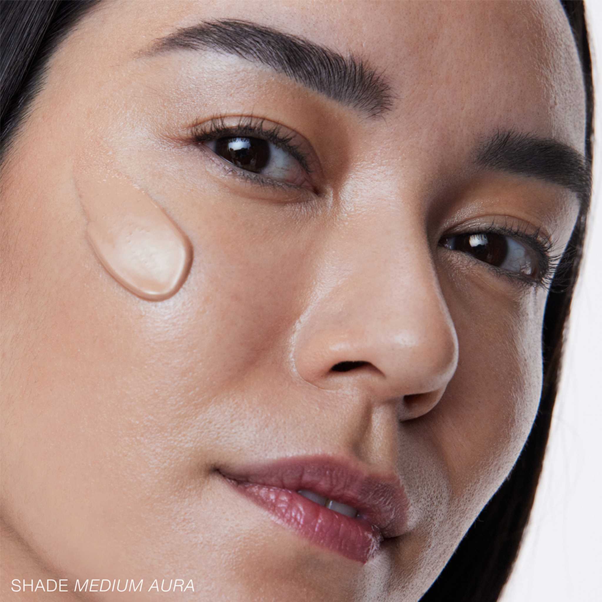 RMS Beauty SuperNatural Radiance Serum Medium Aura swatch on model's cheek 6