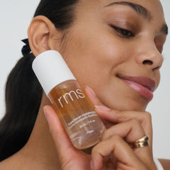 Model holding SuperSerum mist bottle against her cheek