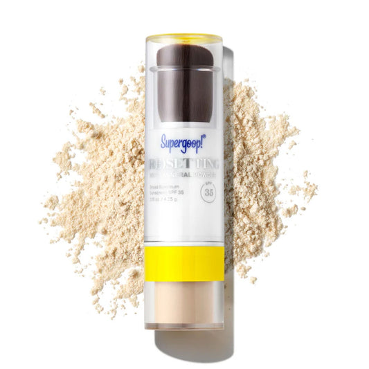 Supergoop Resetting 100% Mineral Powder SPF 35 stick surrounded by loose mineral powder