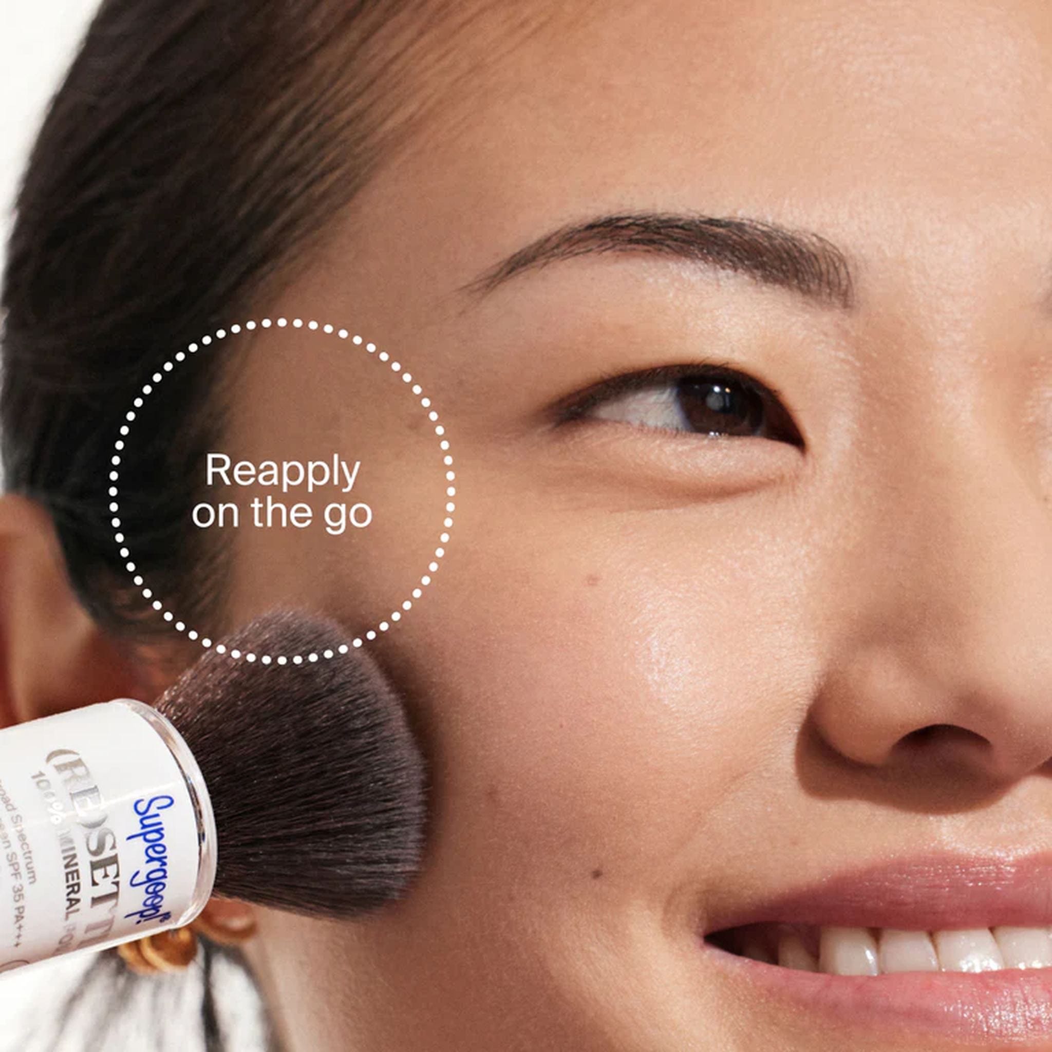 Reapplying Supergoop Resetting Mineral Powder SPF 35 on the go with the built-in brush