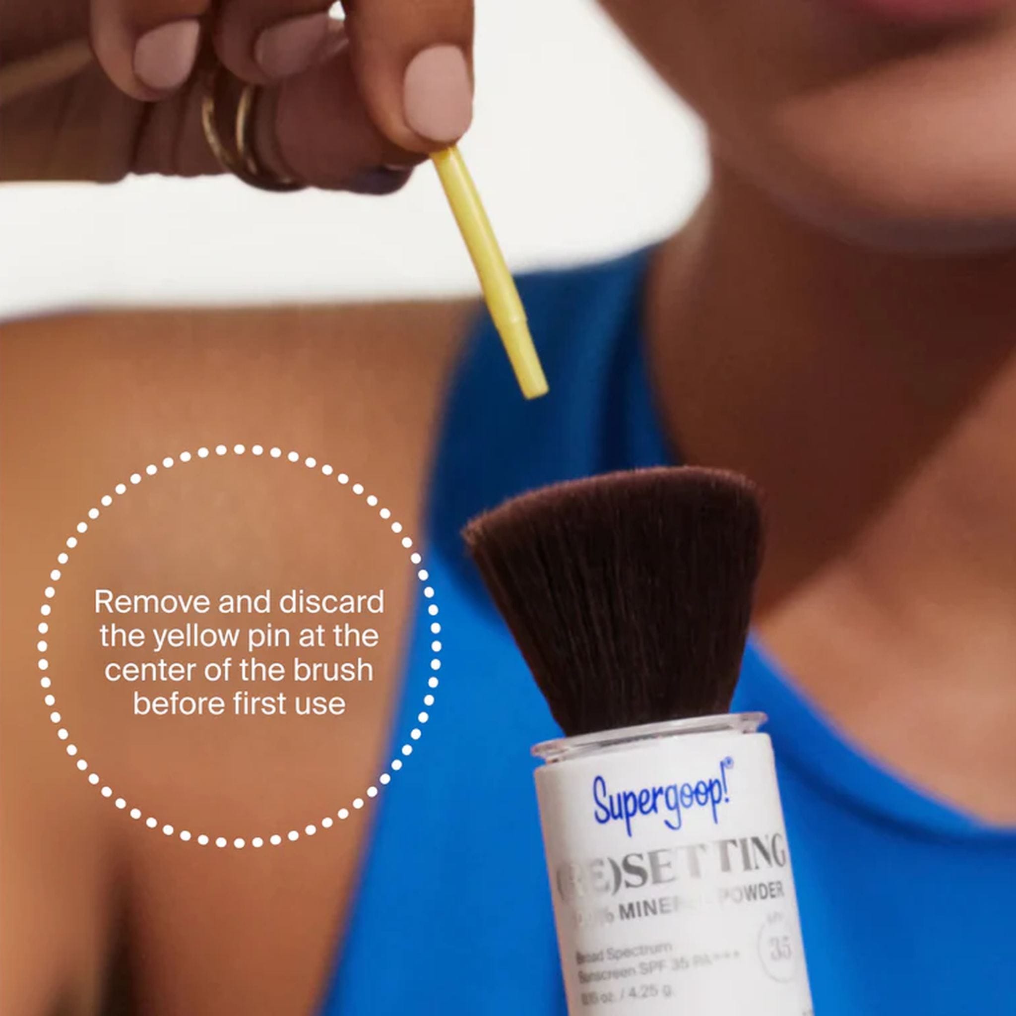 Removing the yellow pin from the Supergoop Resetting Mineral Powder brush before first use