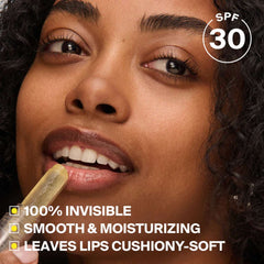 Woman applying Unseen Sunscreen Lip Balm SPF 30 with an invisible smooth moisturizing finish
