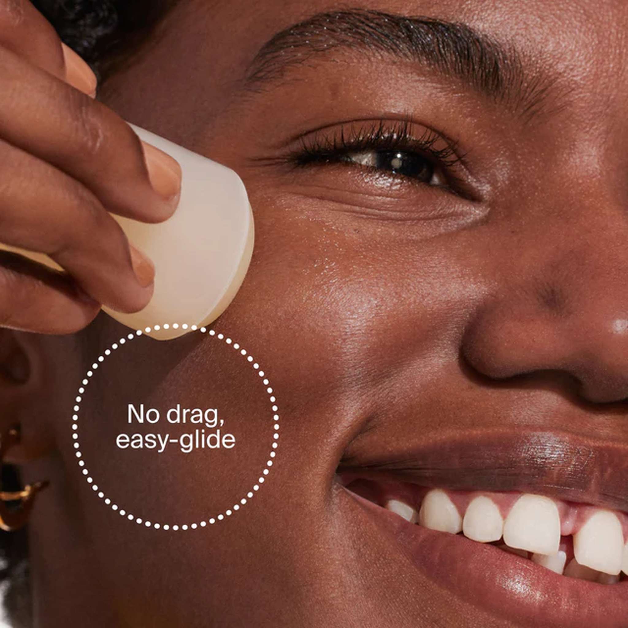 Close-up of Unseen Sunscreen Stick gliding onto cheek with no drag easy-glide application