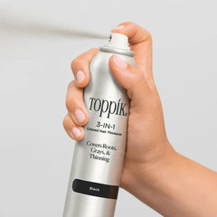 Hand spraying Toppik 3-in-1 Colored Hair Thickener in Black 2