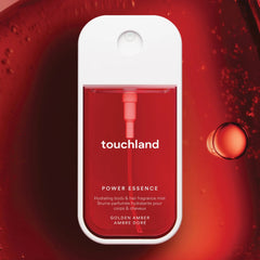 Touchland Power Essence Golden Amber fragrance mist on a glossy red gel texture with bubbles