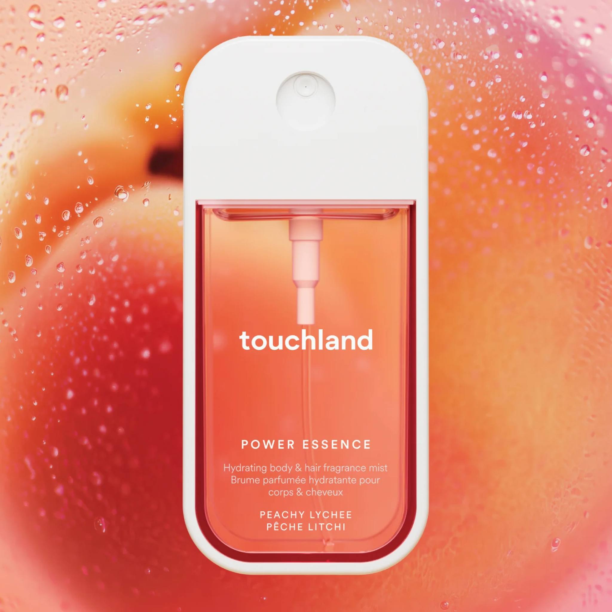 Touchland Power Essence Peachy Lychee fragrance mist against a ripe peach covered in water droplets