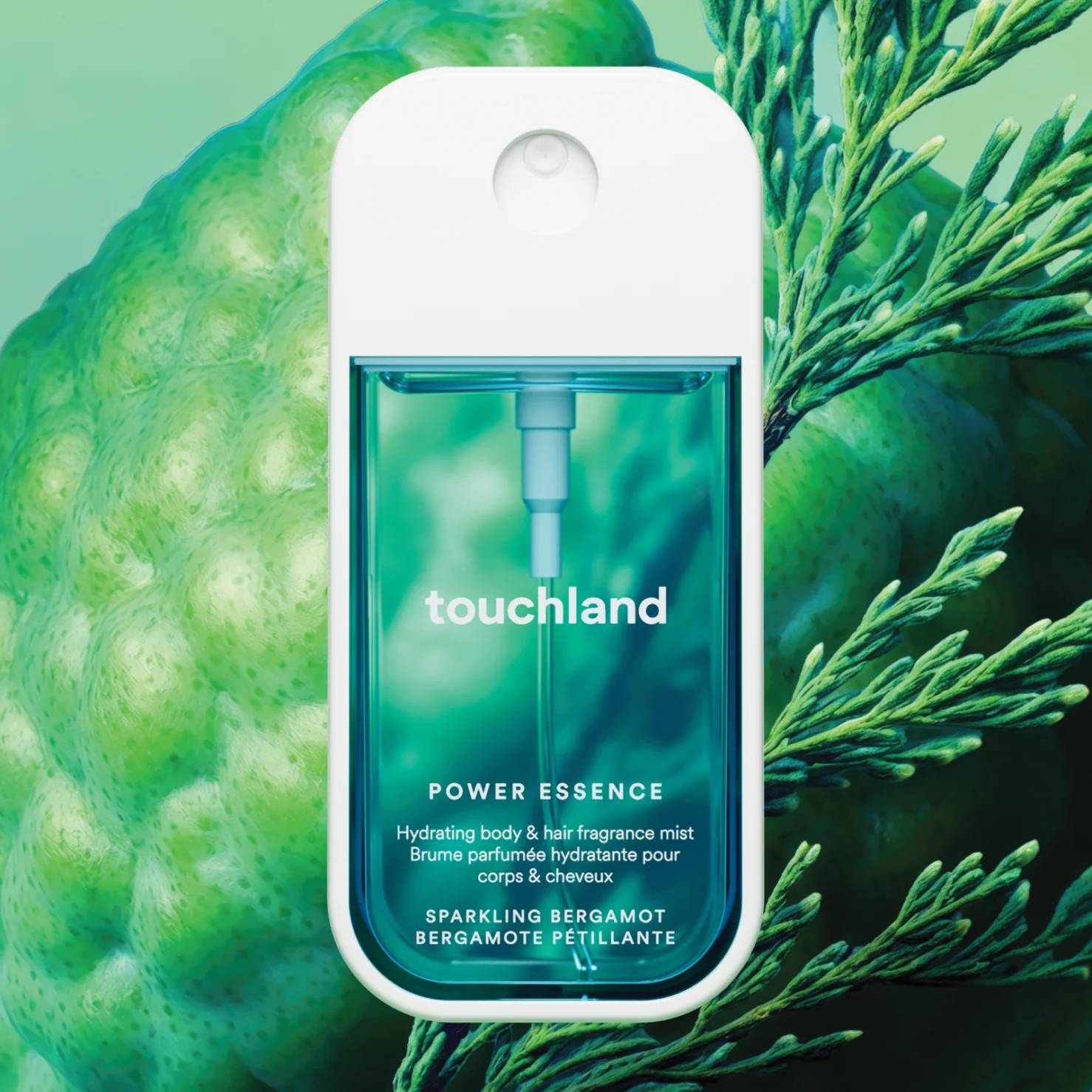 Touchland Power Essence Sparkling Bergamot fragrance mist against green bergamot fruit and cypress sprigs