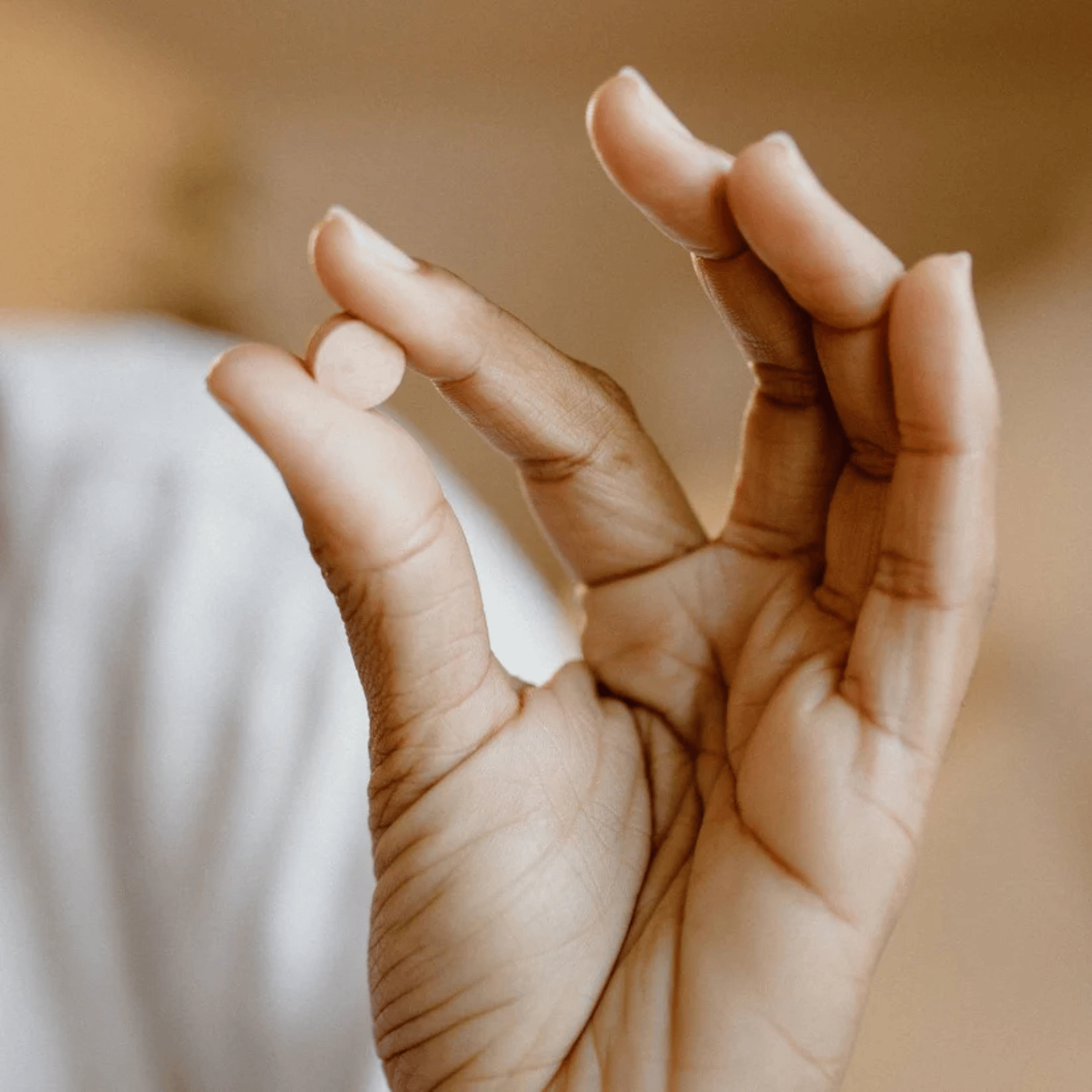 Close-up of a hand holding viviscal pill