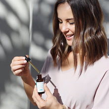 Load image into Gallery viewer, Amy Koberling the Skinthusiast holding a bottle of SkinCeuticals CE Ferulic Antioxidant Serum
